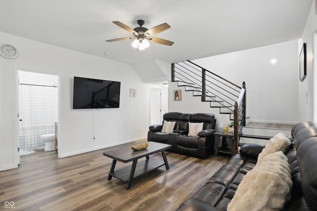 living room featuring wood finished floors, ceiling fan, stairway, and baseboards