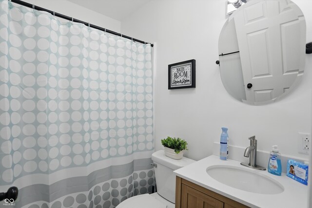 bathroom with toilet, vanity, and curtained shower