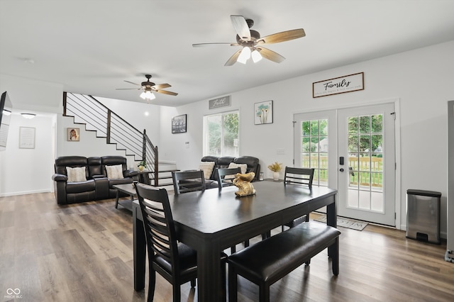 dining room featuring stairs, wood finished floors, ceiling fan, and french doors