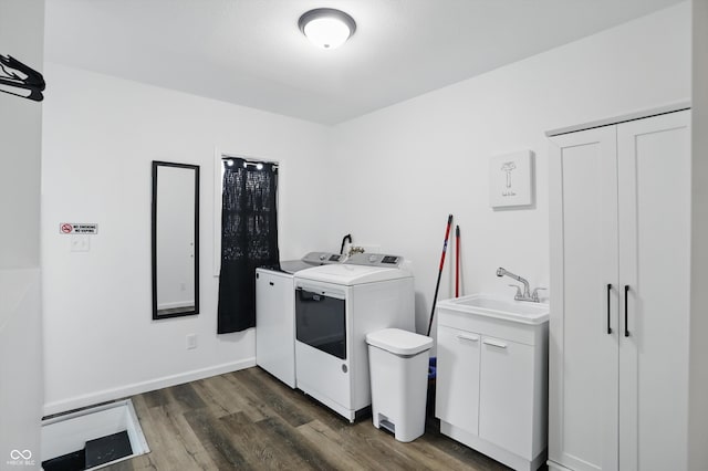 laundry area with independent washer and dryer, dark wood-type flooring, and cabinet space