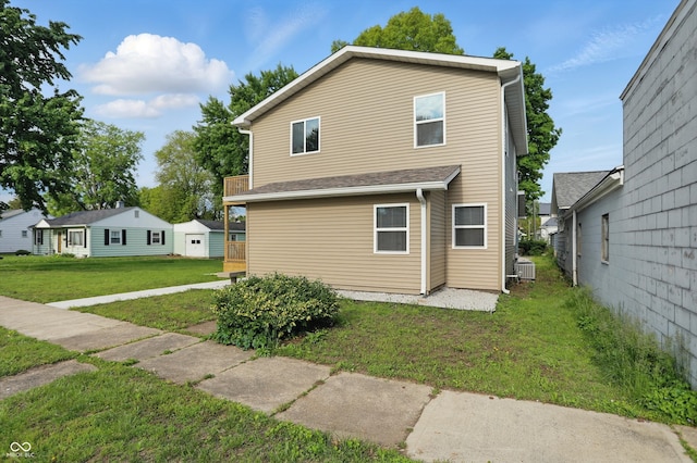 rear view of property with a yard and cooling unit