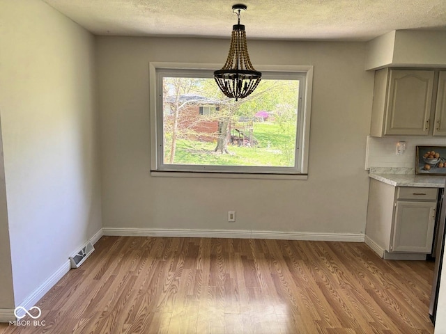 4105 N Cozy Hollow Ln, New Castle, IN 47362 - unfurnished dining area with wood finished floors, a chandelier, and a textured ceiling