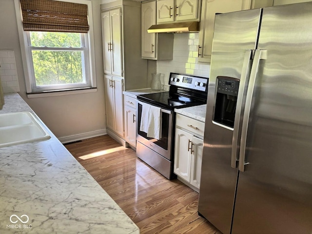 4105 N Cozy Hollow Ln, New Castle, IN 47362 - kitchen with stainless steel appliances, under cabinet range hood, light wood-style flooring, light countertops, and backsplash