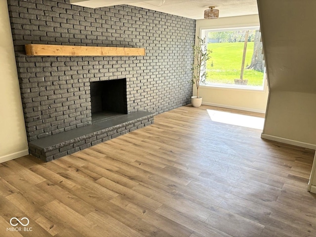 4105 N Cozy Hollow Ln, New Castle, IN 47362 - unfurnished living room featuring a brick fireplace and wood finished floors
