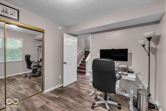 home office featuring wood finished floors, a textured ceiling, and baseboards