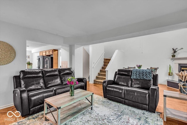 living room with stairs, baseboards, and a tile fireplace