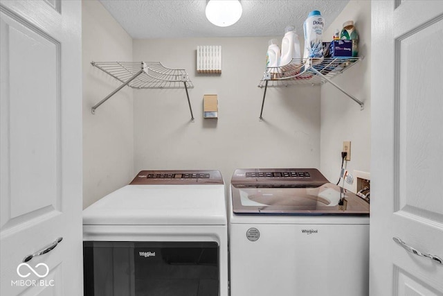 laundry room with washing machine and dryer and a textured ceiling