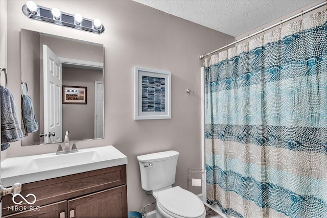 bathroom with vanity, toilet, curtained shower, and a textured ceiling