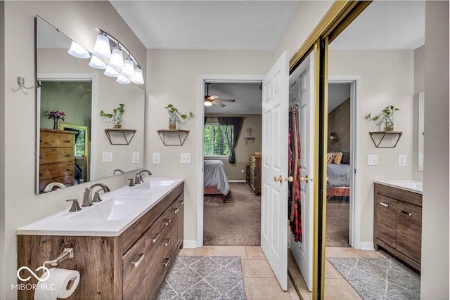 full bathroom with ensuite bath, double vanity, tile patterned floors, and baseboards