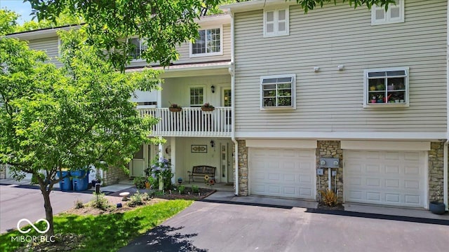 view of front of property with stone siding, driveway, and an attached garage