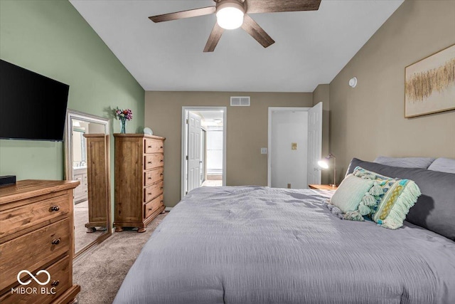 bedroom featuring light colored carpet, a ceiling fan, vaulted ceiling, and connected bathroom
