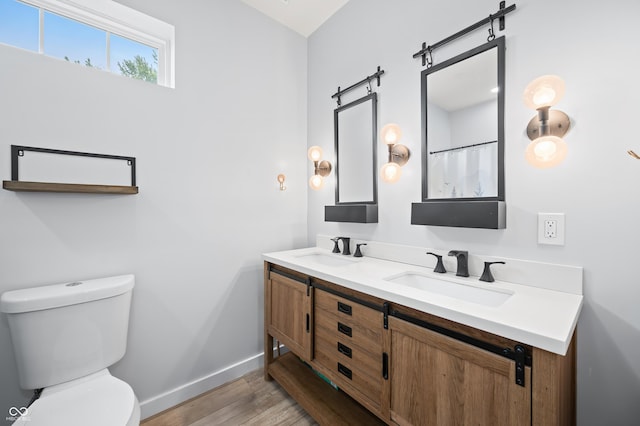 141 W 10th St, Seymour, IN 47274 - full bathroom with baseboards, wood finished floors, toilet, and double vanity