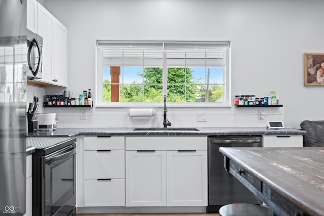 141 W 10th St, Seymour, IN 47274 - kitchen with dishwasher, a sink, white cabinetry, electric stove, and stainless steel refrigerator