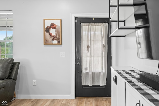 141 W 10th St, Seymour, IN 47274 - kitchen with light wood finished floors, white cabinetry, and baseboards