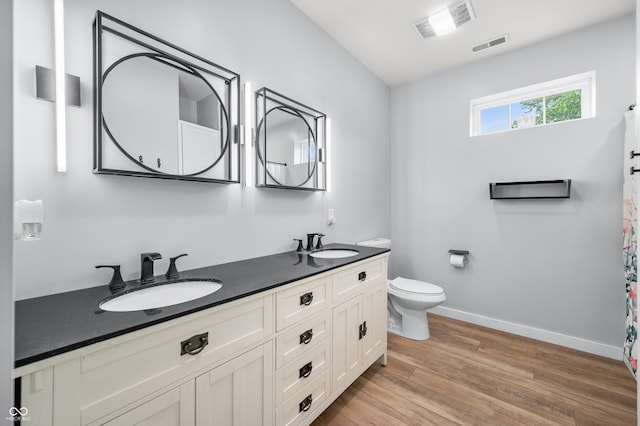141 W 10th St, Seymour, IN 47274 - full bath featuring wood finished floors, double vanity, baseboards, and toilet