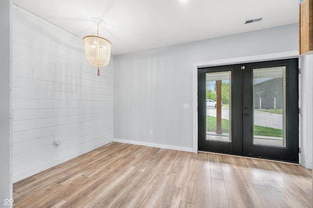 141 W 10th St, Seymour, IN 47274 - unfurnished dining area featuring french doors, light wood-style flooring, a chandelier, and baseboards