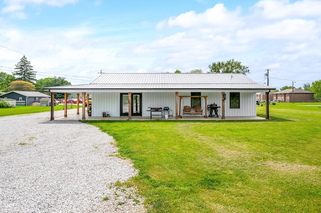 141 W 10th St, Seymour, IN 47274 - back of house featuring driveway, a yard, board and batten siding, and metal roof