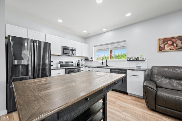 141 W 10th St, Seymour, IN 47274 - kitchen with stainless steel appliances, a sink, open floor plan, white cabinets, and recessed lighting