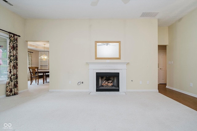 10833 Tournament Ln, Indianapolis, IN 46229 - unfurnished living room with carpet, ceiling fan, and a tiled fireplace