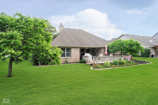 10833 Tournament Ln, Indianapolis, IN 46229 - rear view of house with a deck, a lawn, a shingled roof, a chimney, and brick siding
