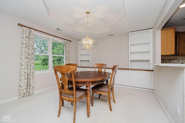 10833 Tournament Ln, Indianapolis, IN 46229 - dining space with a chandelier, built in shelves, light colored carpet, and a raised ceiling