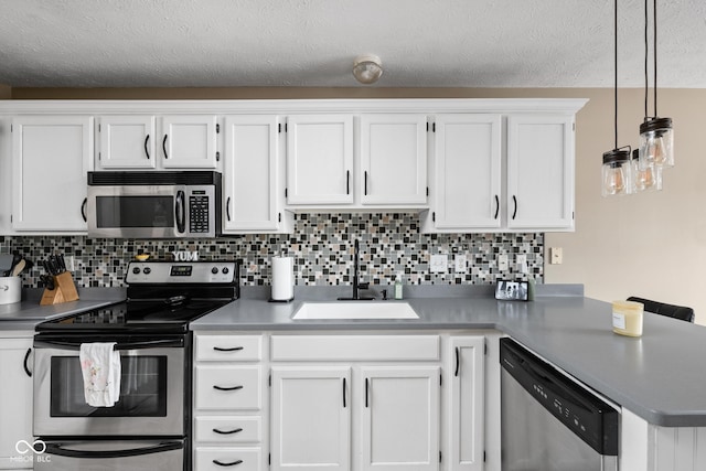 9404 Enclave Dr Unit D, Avon, IN 46123 - kitchen featuring appliances with stainless steel finishes, white cabinets, a peninsula, backsplash, and a textured ceiling