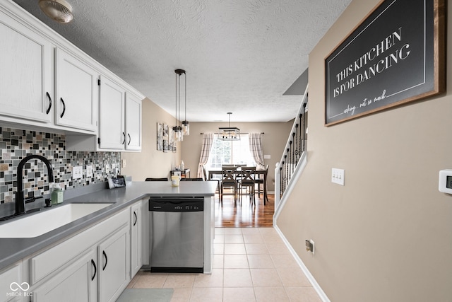 9404 Enclave Dr Unit D, Avon, IN 46123 - kitchen featuring stainless steel dishwasher, a peninsula, white cabinetry, backsplash, and light tile patterned flooring