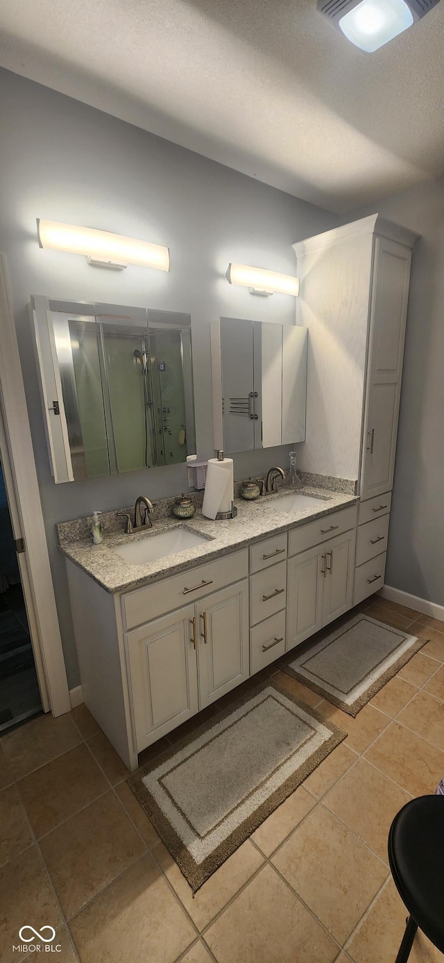 5415 S Chalmers Ct, Bloomington, IN 47403 - bathroom with double vanity, tile patterned floors, a shower stall, and baseboards