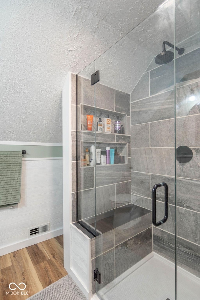 1409 S Northview Dr, Martinsville, IN 46151 - full bath featuring wood finished floors, a stall shower, vaulted ceiling, and a textured ceiling