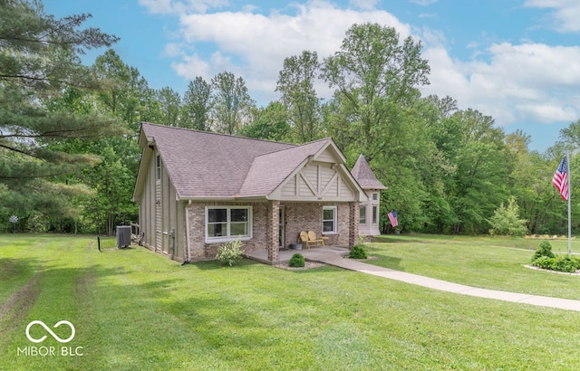 1409 S Northview Dr, Martinsville, IN 46151 - view of front of home with a front yard, brick siding, cooling unit, a shingled roof, and a patio area