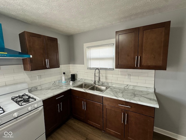 kitchen with white range with gas cooktop, a sink, wall chimney exhaust hood, decorative backsplash, and a textured ceiling