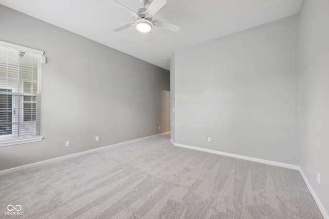 carpeted empty room with baseboards and a ceiling fan