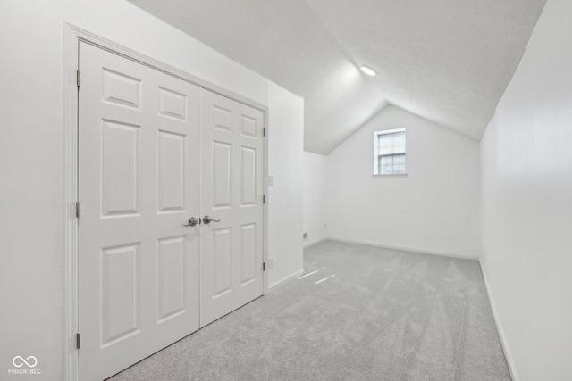 additional living space with carpet floors, lofted ceiling, and baseboards