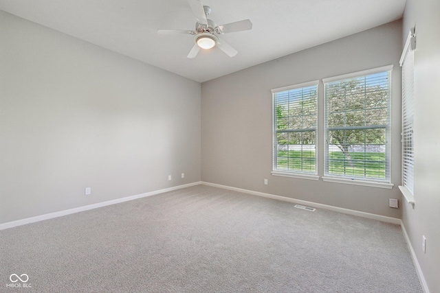 carpeted empty room with baseboards and ceiling fan