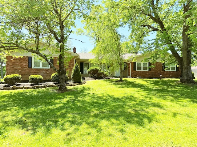 8835 Briarclift Rd, Indianapolis, IN 46256 - view of front of home featuring brick siding, a front lawn, and a chimney