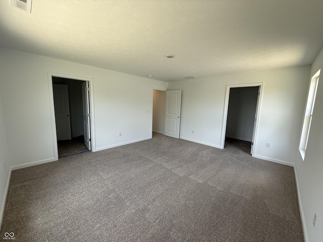 24391 Stout St, Sheridan, IN 46069 - unfurnished bedroom with baseboards, dark colored carpet, and a textured ceiling
