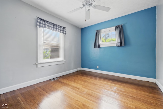 unfurnished room featuring baseboards, wood finished floors, and ceiling fan