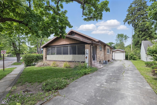 bungalow with an outdoor structure, a front lawn, cooling unit, a detached garage, and concrete driveway