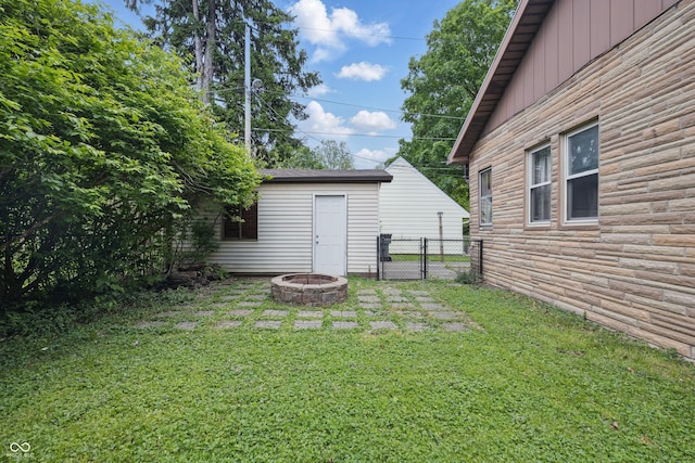 view of yard with a fire pit and an outdoor structure