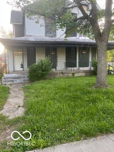 view of front of home featuring covered porch and a front yard