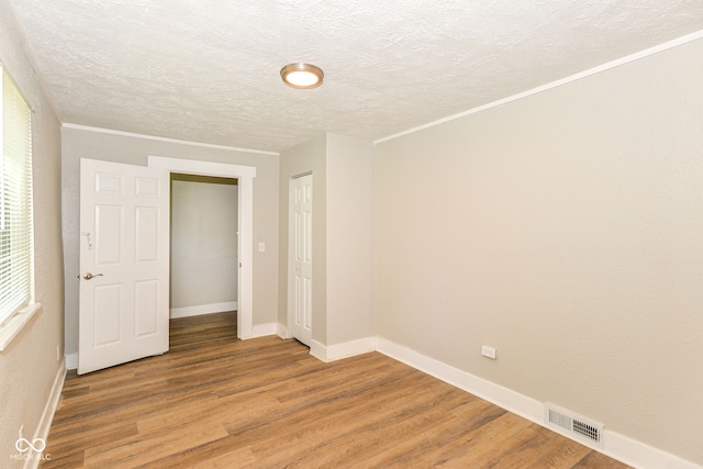 1115 N Keystone Ave, Indianapolis, IN 46201 - unfurnished bedroom featuring light wood-style flooring, a textured ceiling, baseboards, and a closet