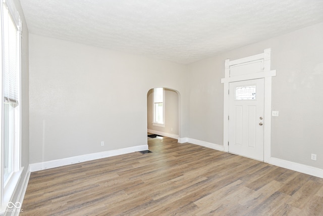 1115 N Keystone Ave, Indianapolis, IN 46201 - entryway featuring arched walkways, wood finished floors, baseboards, and a textured ceiling