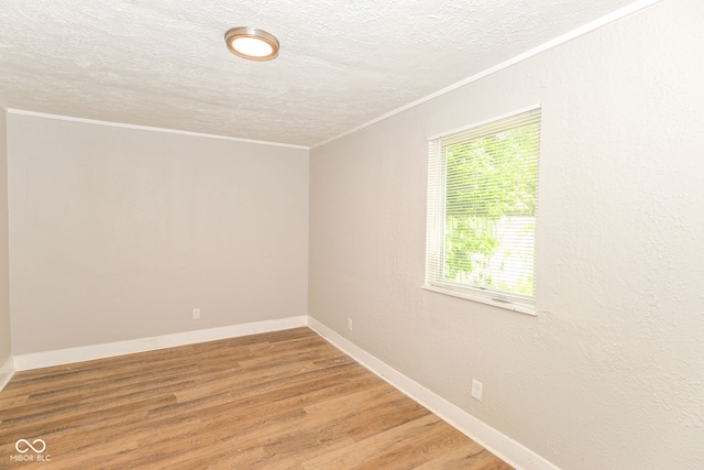 1115 N Keystone Ave, Indianapolis, IN 46201 - unfurnished room featuring ornamental molding, healthy amount of natural light, a textured ceiling, light wood-style flooring, and baseboards