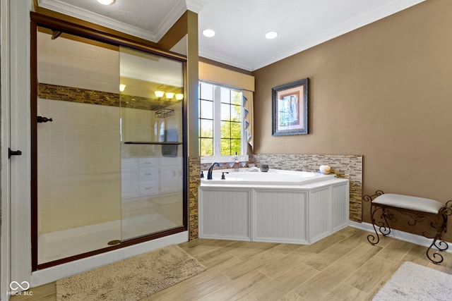 bathroom featuring ornamental molding, a stall shower, a garden tub, wood finish floors, and recessed lighting