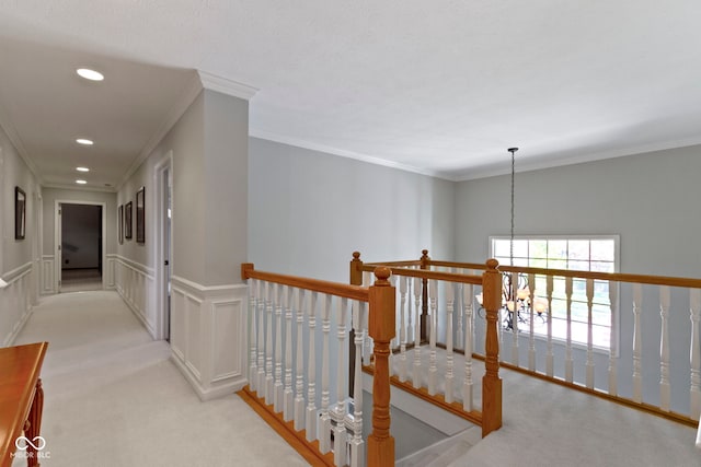 hall featuring carpet, an upstairs landing, crown molding, a chandelier, and recessed lighting