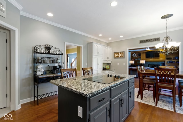 kitchen featuring black electric cooktop, white cabinets, dark wood-style flooring, a kitchen island, and recessed lighting