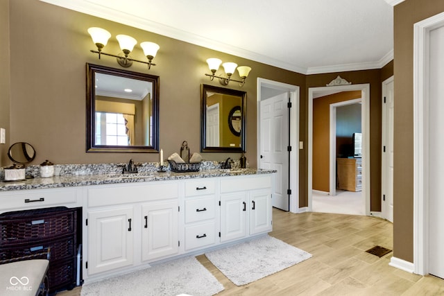bathroom featuring ornamental molding, double vanity, and baseboards