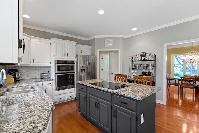 kitchen featuring a sink, appliances with stainless steel finishes, white cabinets, gray cabinets, and wood finished floors