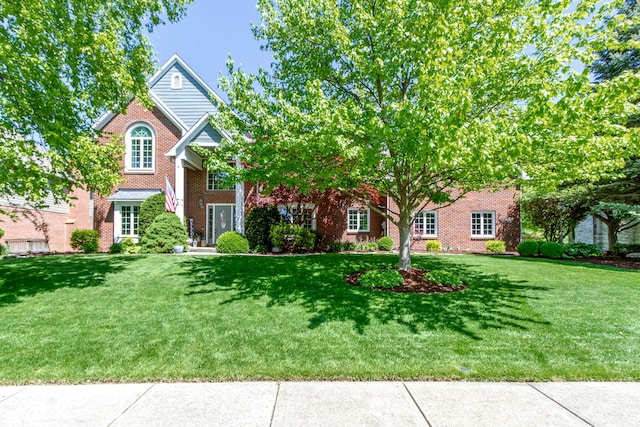 view of front of home featuring a front lawn and brick siding