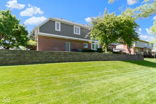 rear view of property featuring brick siding and cooling unit